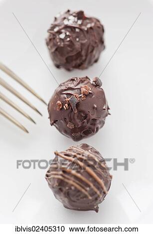 Stock Image - Three chocolate truffles and a fork. Fotosearch