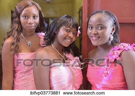 Stock Image - "Three ladies in pink dresses at a wedding, """"Pink Wedding"""", Freetown, Sierra Leone, Africa". Fotosearch