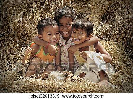 "Three laughing children sitting on rice straw, Cambodia, Southeast Asia, Asia" View Large Photo Image Stock Photo - "Three laughing children sitting on rice straw, Cambodia, Southeast Asia, Asia". Fotosearch