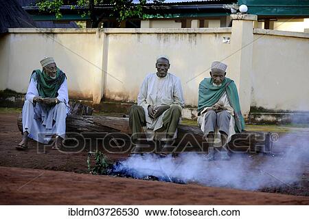 "Three men sitting on the roadside in the village of Idool and supervising a fire, Idool, Adamawa Region, Cameroon, Africa" View Large Photo Image Stock Image - "Three men sitting on the roadside in the village of Idool and supervising a fire, Idool, Adamawa Region, Cameroon, Africa". Fotosearch
