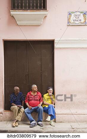 "Three pensioners sitting in front of a building, Old Havana, Havana, Cuba, North America" View Large Photo Image Stock Photo - "Three pensioners sitting in front of a building, Old Havana, Havana, Cuba, North America". Fotosearch