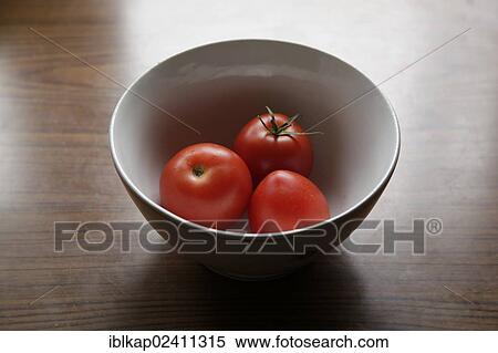 Stock Photography - Three tomatoes in a bowl. Fotosearch