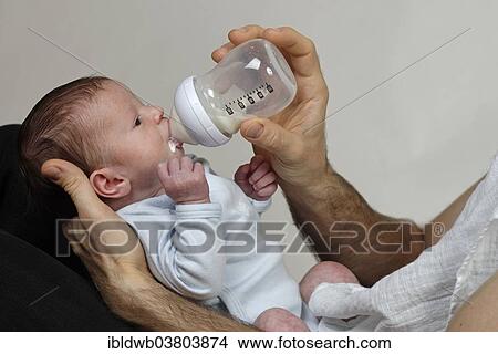 Three-week-old infant boy is fed with the bottle by his father View Large Photo Image Picture - Three-week-old infant boy is fed with the bottle by his father. Fotosearch
