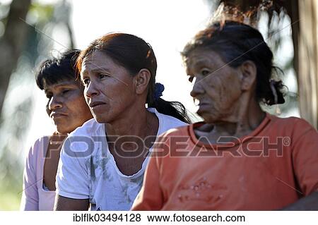 Stock Photo - "Three women with worried facial expressions, in a community of Guarani Indians, Jaguary, Caaguazu Department, Paraguay, South America". Fotosearch