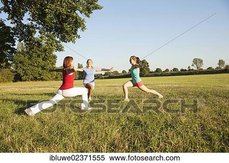 Three young women doing gymnastics exercises together in a meadow View Large Photo Image Stock Photography - Three young women doing gymnastics exercises together in a meadow. Fotosearch
