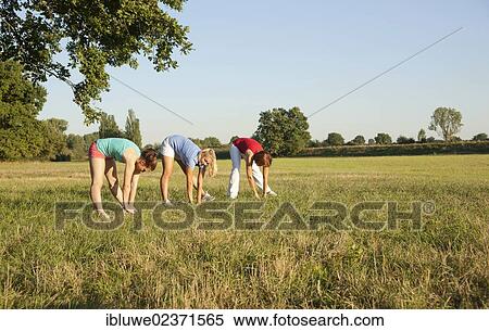 Three young women doing gymnastics exercises together in a meadow View Large Photo Image Stock Photography - Three young women doing gymnastics exercises together in a meadow. Fotosearch