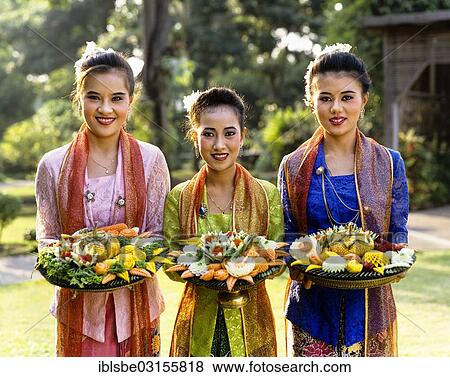 "Three young women dressed in traditional costumes holding trays of carved exotic fruits, Rose Garden, Thailand, Asia" View Large Photo Image Stock Photo - "Three young women dressed in traditional costumes holding trays of carved exotic fruits, Rose Garden, Thailand, Asia". Fotosearch