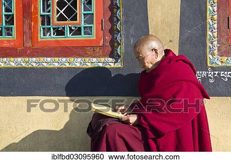 Stock Image - "Tibetan monk reading the holy scriptures at the foot of Boudnath Stupa, Kathmandu Valley, Kathmandu, Kathmandu District, Bagmati Zone, Nepal, Asia". Fotosearch
