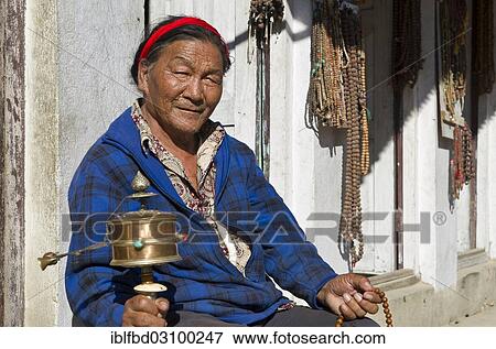 "Tibetan pilgrim turning a prayer mill, Kathmandu, Kathmandu District, Bagmati Zone, Nepal, Asia" View Large Photo Image Stock Photo - "Tibetan pilgrim turning a prayer mill, Kathmandu, Kathmandu District, Bagmati Zone, Nepal, Asia". Fotosearch