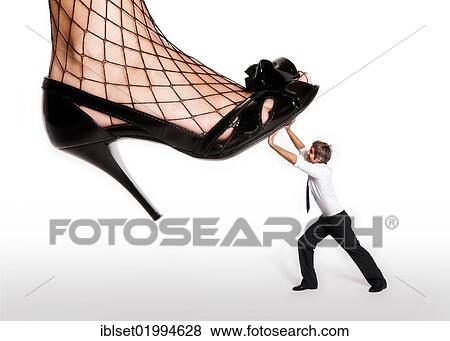 "Tiny little man fending off a woman's foot with high heels, symbolic image for suppression" View Large Photo Image Stock Photo - "Tiny little man fending off a woman's foot with high heels, symbolic image for suppression". Fotosearch