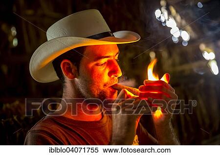 "Tobacco farmer Luis Manne Alvares Rodrigues lighting a Havana cigar, tobacco farm, Vinales Valley, Vinales, Pinar del Rio Province, Cuba, North America" View Large Photo Image Stock Photography - "Tobacco farmer Luis Manne Alvares Rodrigues lighting a Havana cigar, tobacco farm, Vinales Valley, Vinales, Pinar del Rio Province, Cuba, North America". Fotosearch