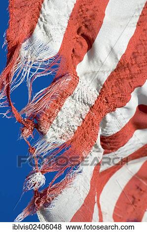 Torn American flag against blue sky View Large Photo Image Stock Photo - Torn American flag against blue sky. Fotosearch