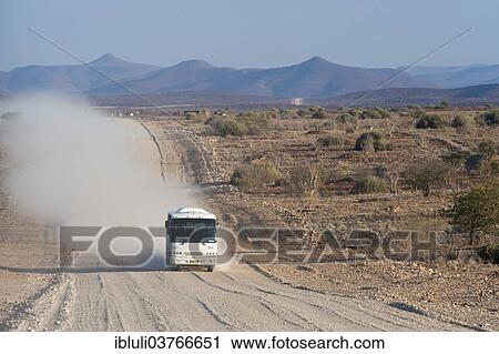 "Tourist bus driving in a cloud of dust on a wide, dusty gravel road, Kunene Region, Namibia, Africa" View Large Photo Image Stock Image - "Tourist bus driving in a cloud of dust on a wide, dusty gravel road, Kunene Region, Namibia, Africa". Fotosearch