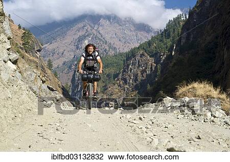 "Tourist cycling on a gravel road in Marsyangdi Yuni valley, Annapurna Region, Nepal, Asia" View Large Photo Image Stock Image - "Tourist cycling on a gravel road in Marsyangdi Yuni valley, Annapurna Region, Nepal, Asia". Fotosearch