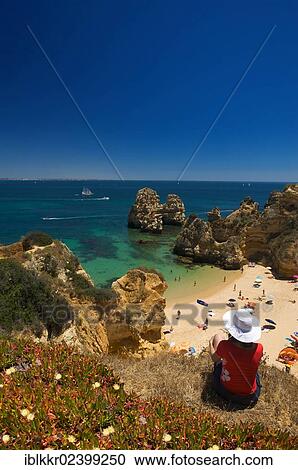 "Tourist overlooking the bay of Praia do Camilo, Algarve, Portugal, Europe" View Large Photo Image Stock Image - "Tourist overlooking the bay of Praia do Camilo, Algarve, Portugal, Europe". Fotosearch