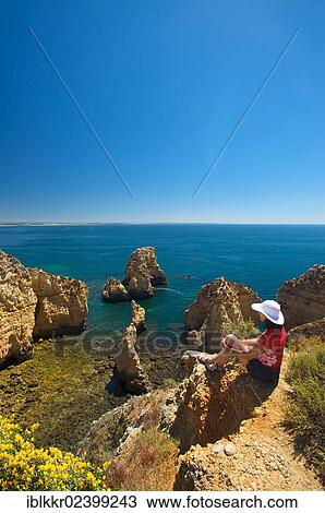 "Tourist overlooking the cliffs of Ponta da Piedade, Algarve, Portugal, Europe" View Large Photo Image Stock Image - "Tourist overlooking the cliffs of Ponta da Piedade, Algarve, Portugal, Europe". Fotosearch