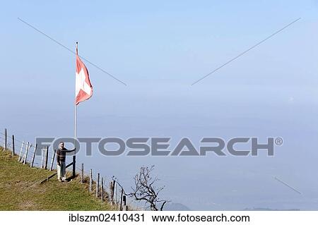 "Tourist standing beside a Swiss flag, Rigi, Switzerland, Europe" View Large Photo Image Stock Image - "Tourist standing beside a Swiss flag, Rigi, Switzerland, Europe". Fotosearch