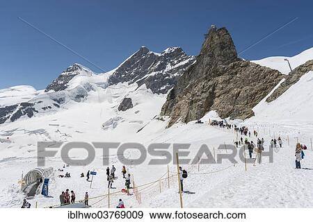 Stock Photo - "Tourists at the Jungfraujoch saddle, behind the massif of Mt. Jungfrau, Swiss Alps Jungfrau-Aletsch UNESCO World Heritage, Berne Canton, Switzerland, Europe". Fotosearch