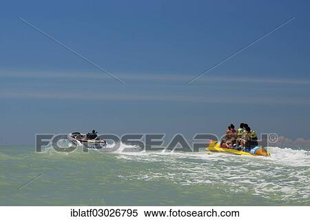 Stock Photography - "Tourists being pulled on a banana boat ride, Adria, Bibione, Veneto Region, Italy, Europe". Fotosearch