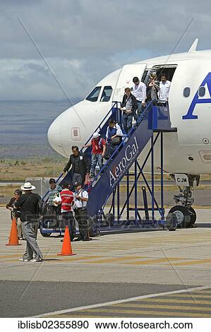Stock Image - "Tourists getting off a plane of AeroGal airlines at Baltra airport island, Galapagos, Ecuador, South America". Fotosearch