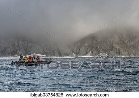 "Tourists in an inflatable boat approaching Herald Island, a UNESCO World Heritage Site, Herald Island, Far Eastern Federal District, Russia, Europe" View Large Photo Image Stock Photograph - "Tourists in an inflatable boat approaching Herald Island, a UNESCO World Heritage Site, Herald Island, Far Eastern Federal District, Russia, Europe". Fotosearch