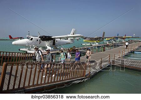 Stock Photo - "Tourists leaving the pontoon with hydroplanes moored, De Havilland Canada DHC-6 300 Twin Otter, Male International Airport, Hulhule, Maldives, Asia". Fotosearch