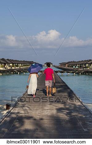 Stock Image - "Tourists on a jetty, water bungalows on Paradise Island, Lankanfinolhu, North Male Atoll, Maldives, Asia". Fotosearch