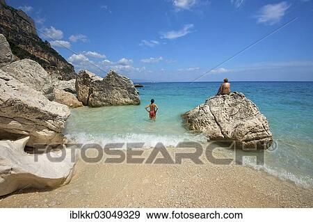 Stock Photo - "Tourists on the beach, Cala Goloritze, Golfo di Orosei, Parco Nazionale del Gennargentu e Golfo di Goloritze, Sardinia, Italy, Europe". Fotosearch