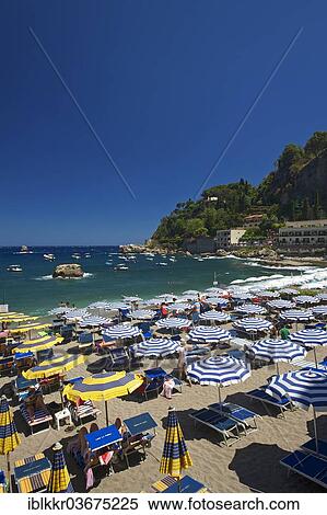 Stock Photography - "Tourists on the beach, umbrellas and sun loungers, Bay of Mazzaro, Taormina, Province of Messina, Sicily, Italy, Europe". Fotosearch