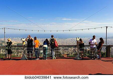 Stock Image - "Tourists overlooking the city from Tibidabo Amusement Park, Barcelona, â€‹â€‹Catalonia, Spain, Europe". Fotosearch