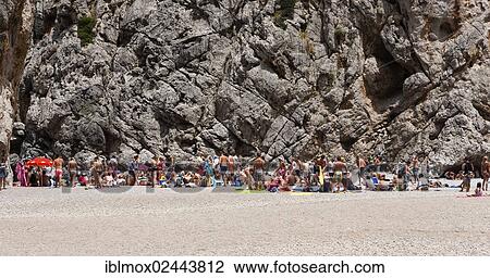Stock Image - "Tourists sunbathing in Torrent de Pareis Gorge, Cala de Sa Calobra Bay, Sa Calobra, Tramuntana Mountains, Majorca, Balearic Islands, Spain, Europe". Fotosearch