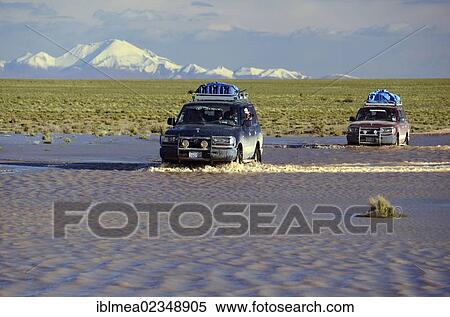 "Tourists traveling through the wild landscape of the Altiplano high plateau in off-road vehicles, Bolivia, South America" View Large Photo Image Stock Photography - "Tourists traveling through the wild landscape of the Altiplano high plateau in off-road vehicles, Bolivia, South America". Fotosearch