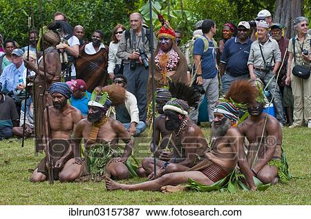 "Tourists watching men in colourfully decorated costumes with face paint celebrating at the traditional Sing Sing gathering in the highlands, Paya, Papua New Guinea, Oceania" View Large Photo Image Stock Photo - "Tourists watching men in colourfully decorated costumes with face paint celebrating at the traditional Sing Sing gathering in the highlands, Paya, Papua New Guinea, Oceania". Fotosearch