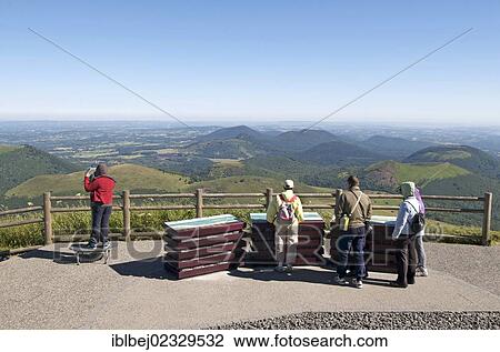 Stock Image - "Tourists with view of the volcanic landscape of the Chaine des Puys, Auvergne, France, Europe". Fotosearch