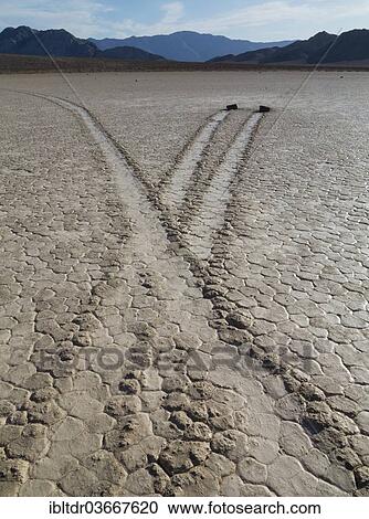 Stock Image - "Traces generated by the mysterious wandering rocks in the so-called Racetrack, a dry lake bed, Death Valley National Park, Mojave Desert, California, United States, North America". Fotosearch