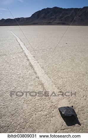 "Track created by one of the mysterious moving rocks at the """"Racetrack"""", a dry lakebed or playa, Death Valley, Death Valley National Park, California, USA" View Large Photo Image Stock Image - "Track created by one of the mysterious moving rocks at the """"Racetrack"""", a dry lakebed or playa, Death Valley, Death Valley National Park, California, USA". Fotosearch