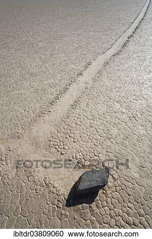 "Track created by one of the mysterious moving rocks at the """"Racetrack"""", a dry lakebed or playa, Death Valley, Death Valley National Park, California, USA" View Large Photo Image Stock Image - "Track created by one of the mysterious moving rocks at the """"Racetrack"""", a dry lakebed or playa, Death Valley, Death Valley National Park, California, USA". Fotosearch