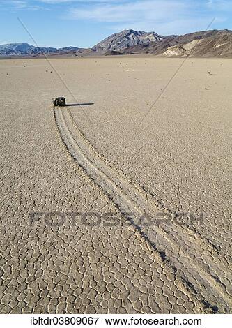 "Track created by one of the mysterious moving rocks at the """"Racetrack"""", a dry lakebed or playa, Death Valley, Death Valley National Park, California, USA" View Large Photo Image Stock Photo - "Track created by one of the mysterious moving rocks at the """"Racetrack"""", a dry lakebed or playa, Death Valley, Death Valley National Park, California, USA". Fotosearch