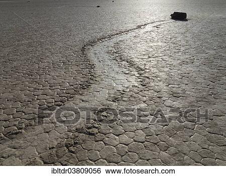Stock Photograph - "Track created by one of the mysterious moving rocks at the """"Racetrack"""", a dry lakebed or playa, Death Valley, Death Valley National Park, California, USA". Fotosearch