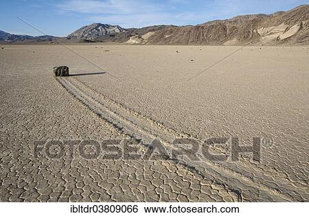"Track created by one of the mysterious moving rocks at the """"Racetrack"""", a dry lakebed or playa, Death Valley, Death Valley National Park, California, USA" View Large Photo Image Stock Photograph - "Track created by one of the mysterious moving rocks at the """"Racetrack"""", a dry lakebed or playa, Death Valley, Death Valley National Park, California, USA". Fotosearch