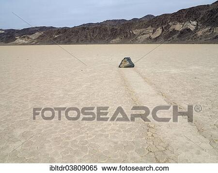 "Track created by one of the mysterious moving rocks at the """"Racetrack"""", a dry lakebed or playa, Death Valley, Death Valley National Park, California, USA" View Large Photo Image Stock Photography - "Track created by one of the mysterious moving rocks at the """"Racetrack"""", a dry lakebed or playa, Death Valley, Death Valley National Park, California, USA". Fotosearch