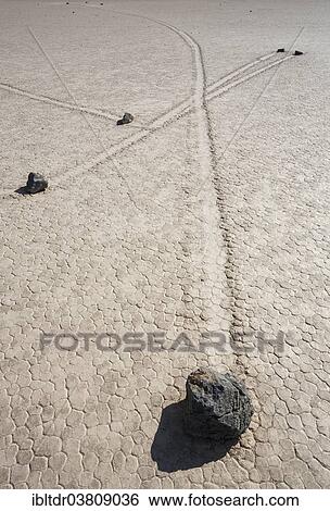 Stock Photograph - "Tracks created by the mysterious moving rocks at the """"Racetrack"""", a dry lakebed or playa, Death Valley, Death Valley National Park, California, USA". Fotosearch