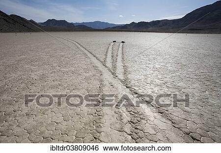 "Tracks created by the mysterious moving rocks at the """"Racetrack"""", a dry lakebed or playa, Death Valley, Death Valley National Park, California, USA" View Large Photo Image Stock Photograph - "Tracks created by the mysterious moving rocks at the """"Racetrack"""", a dry lakebed or playa, Death Valley, Death Valley National Park, California, USA". Fotosearch