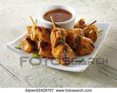 Stock Photo - Traditional oriental satay with chilli dipping sauce. Fotosearch