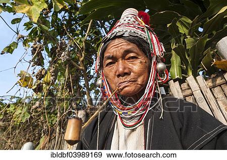 Stock Photo - "Traditionally dressed elderly woman from the Akha people, hill tribe, ethnic minority, smoking a pipe, portrait, Chiang Rai Province, Northern Thailand, Thailand, Asia". Fotosearch