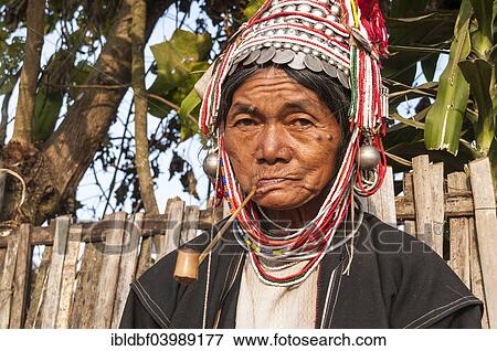 Stock Photo - "Traditionally dressed elderly woman from the Akha people, hill tribe, ethnic minority, smoking a pipe, portrait, Chiang Rai Province, Northern Thailand, Thailand, Asia". Fotosearch