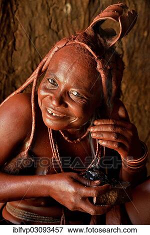 "Traditionally dressed Himba woman in her hut, applying perfume, Purros Traditional Village, Purros, Kaokoland, Kunene, Namibia, Africa" View Large Photo Image Stock Photo - "Traditionally dressed Himba woman in her hut, applying perfume, Purros Traditional Village, Purros, Kaokoland, Kunene, Namibia, Africa". Fotosearch