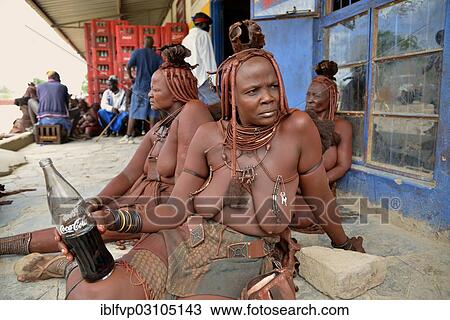 "Traditionally dressed Himba woman drinking a coke in front of a bar, Opuwo, Kaokoland, Kunene, Namibia, Africa" View Large Photo Image Stock Image - "Traditionally dressed Himba woman drinking a coke in front of a bar, Opuwo, Kaokoland, Kunene, Namibia, Africa". Fotosearch