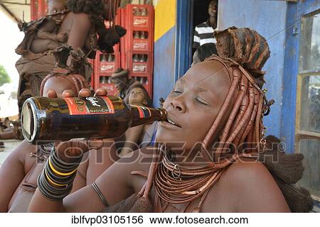 "Traditionally dressed Himba woman drinking a Black Label beer in front of a bar, Opuwo, Kaokoland, Kunene, Namibia, Africa" View Large Photo Image Stock Photograph - "Traditionally dressed Himba woman drinking a Black Label beer in front of a bar, Opuwo, Kaokoland, Kunene, Namibia, Africa". Fotosearch