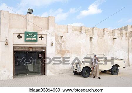 Stock Photo - "Traditionally dressed man standing next to a pickup truck, Sharjah, Emirate of Sharjah, United Arab Emirates, Asia". Fotosearch